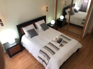a bedroom with a large bed and a mirror at Appartement jusqu'à 6 personnes sur la presqu'île de Peniche surf Portugal in Peniche