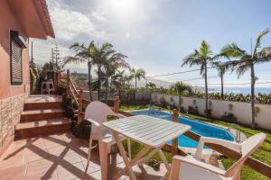 a patio with a table and chairs next to a swimming pool at Casa Victor - Apartment Jorge in La Orotava
