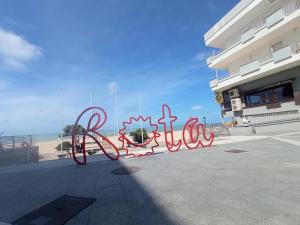 um sinal que diz olá em frente a um edifício em Casa Reyes em Rota