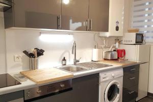 a kitchen with a sink and a washing machine at "Voyage en mer" splendide T3 lumineux, Wi fi et PARKING gratuit in Toulon
