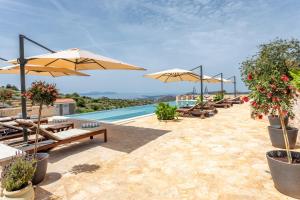 a pool with umbrellas and chairs and a pool at Vidikovac Levanda Luxury Apartments in Hvar