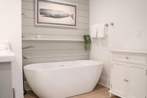 a white bathroom with a large white bath tub at Thomas Sea Suites at Harbourtown in Plymouth +54 photos