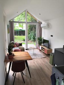 a living room with a table and a couch at Huisje Bloemendal in Balkbrug