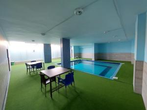a pool in a room with a table and chairs at Thara Real Estate in Sowayma