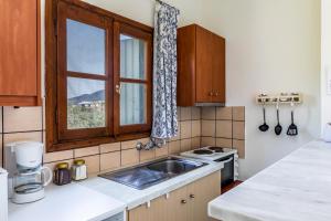 cocina con fregadero y ventana en Estia A - Studios & Apartments, en Skopelos Town