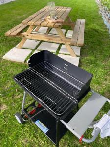 una barbacoa junto a una mesa de picnic en Le Grand Marguit*** sur la Côte Basco-Landaise, en Tarnos