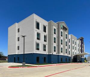 a white building with a street light in front of it at MainStay Suites Dallas Northwest - Irving in Dallas