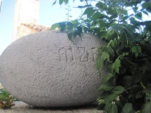 a large rock sitting next to a plant at Guesthouse Villa Galovic in Brseč