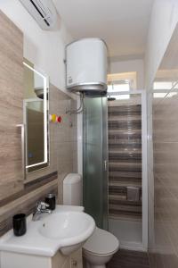 un bagno con un water, un lavandino e uno specchio di Apartman Toni a Spalato (Split)