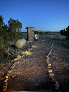a stone path leading to a outhouse in a field at Star Garden Az in Valle