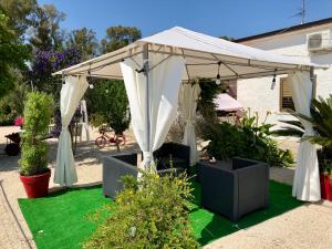 a white canopy on a lawn with plants at Villa Cenzina in Marina di Pisticci