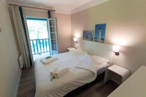 um quarto com uma cama com lençóis brancos e uma janela em Bright 50 M For 6 With Balcony And Garden em Moliets-et-Maa