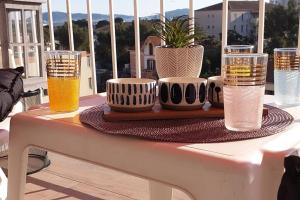 una mesa con cuatro vasos de cerveza en un balcón en Le Doux voyage T3, vue Mer, Wi Fi, PARKING gratuit, en Toulon