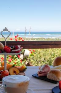 una mesa con comida y vistas al océano en La Minditta en San Teodoro