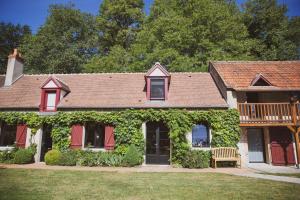 una casa ricoperta di edera verde con un ponte di Domaine de Montizeau a Lailly-en-Val