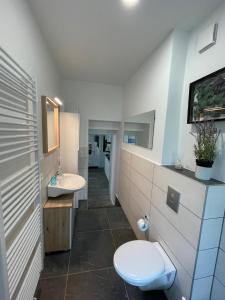 a bathroom with two sinks and a toilet in it at Heimathafen Crange in Herne