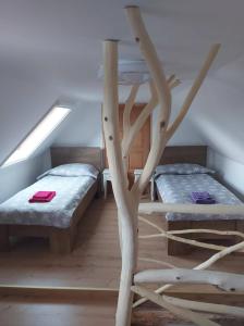 una camera con due letti e un albero di Oliva Verde Apartman a Bárdudvarnok