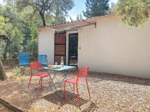 una mesa y cuatro sillas frente a un cobertizo en Domaine Colibri en Provence, en Pujaut