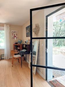 Pujaut的住宿－Domaine Colibri en Provence，一间带玻璃门和书桌的客厅