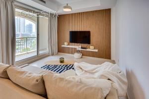ein Wohnzimmer mit einem Sofa und einem großen Fenster in der Unterkunft Mosela Tower by Emaar, The Views and Greens in Dubai