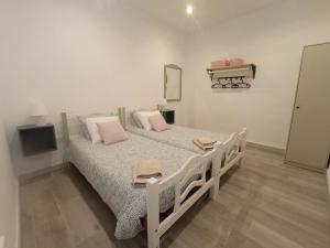 a bedroom with a bed with pink pillows and a tv at Casa Reyes in Rota