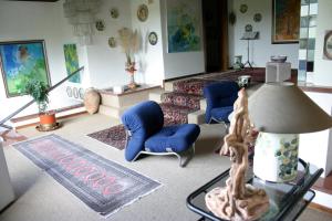 a living room with blue chairs and a lamp at B&B Cà d'Artisti in Caorle