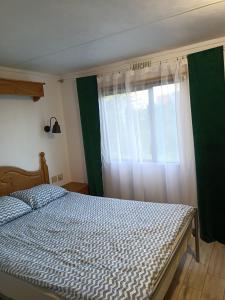 a bedroom with a bed and a window at Domek KAMA in Giżycko