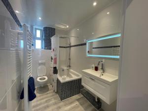 GehrdenにあるModerne 4 Zimmer Apartment mit Bergblick Stadtzentrum Contactless Check-inの洗面台とトイレを備えた白いバスルーム +59枚の写真