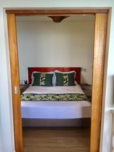 a bed with a wooden frame in a bedroom at Fare Anuanua in Haapiti