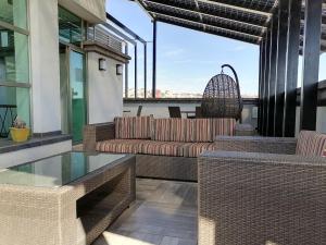 eine Terrasse mit Korbmöbeln und einem Glastisch in der Unterkunft Grand Marques in San Juan de los Lagos