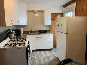 uma cozinha com armários brancos e um frigorífico branco em The Navy em Oswego