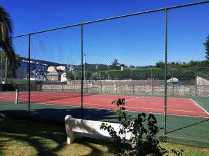 a fence on a tennis court with two tennis courts at Omega 1 in Viveiro