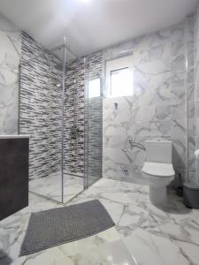 een badkamer met een toilet en een glazen douche bij Holiday home N&S in Bar