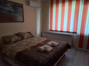 a bedroom with a bed with towels on it at Dima's place in Kazanlŭk