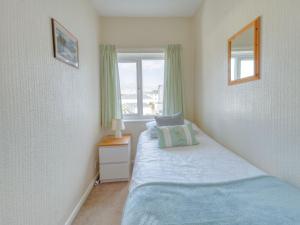 a small bedroom with a bed and a window at Apartment 3 - 2 Bedroom town views in Paignton