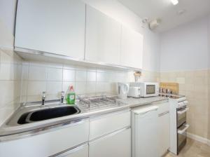 a kitchen with a sink and a microwave at Apartment 3 - 2 Bedroom town views in Paignton