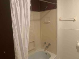 a bathroom with a tub and a shower with a shower curtain at The Navy 2 in Oswego