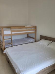 a bedroom with two bunk beds with white sheets at Sunny House Apartments Doni Štoj in Bregvija