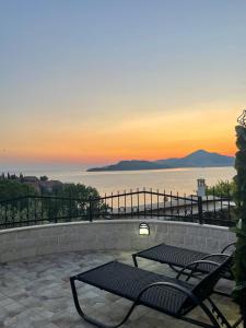 a patio with two benches and a view of the ocean at Monte Perla Residence in Sveti Stefan