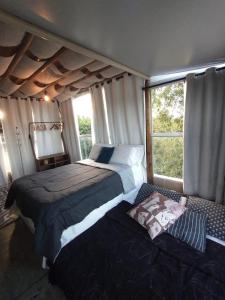 a bedroom with two beds and a window at Galinha d'Angola in Porto De Galinhas