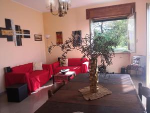 a living room with a table and a red couch at Villa Iside in Rogiano Gravina