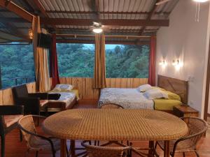 Habitación con mesa, cama y ventana en Santa Juana Lodge & Nature Reserve, en Quepos