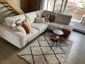 a living room with a white couch and a rug at -AYANA SUITE- 2 BEDROOM SUITE WITH GARAGE KNOKKE in Knokke-Heist