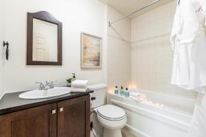 a bathroom with a sink and a toilet and a tub at Townhouse With Free Shuttle To Tremblant Resort in Mont-Tremblant +23 photos