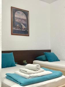 two beds with towels on them in a room at Monte Perla Residence in Sveti Stefan
