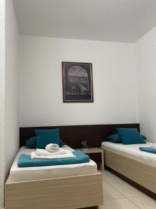 a room with two beds with blue pillows at Monte Perla Residence in Sveti Stefan