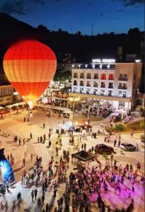 a group of people walking around a town with a hot air balloon at Hotel Permeti in Përmet