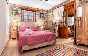 sypialnia z różowym łóżkiem i ręcznikami w obiekcie Flores Hotel Alaçatı w mieście Alaçatı