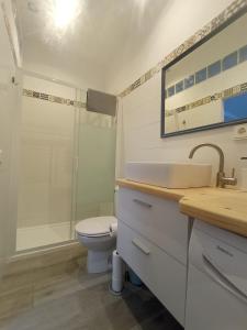 een badkamer met een wastafel, een toilet en een douche bij Casa Reyes in Rota