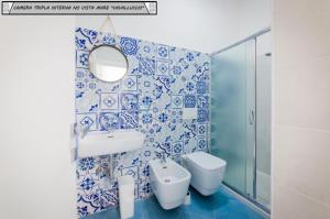 a blue and white bathroom with a sink and a mirror at Zagma Un Passo Dal Mare in Canneto